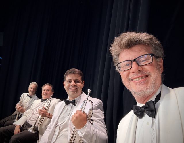 Luis Engelke with a trumpet section in white dinner jackets