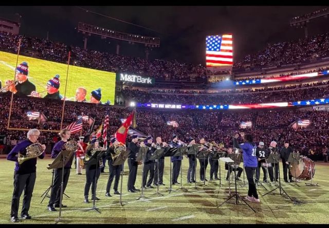 Brass ensemble performing the national anthem at a football stadium