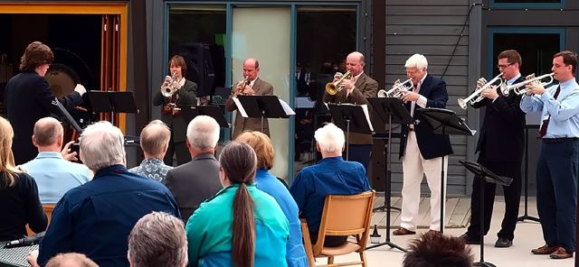 Brass ensemble performing outdoors for an audience