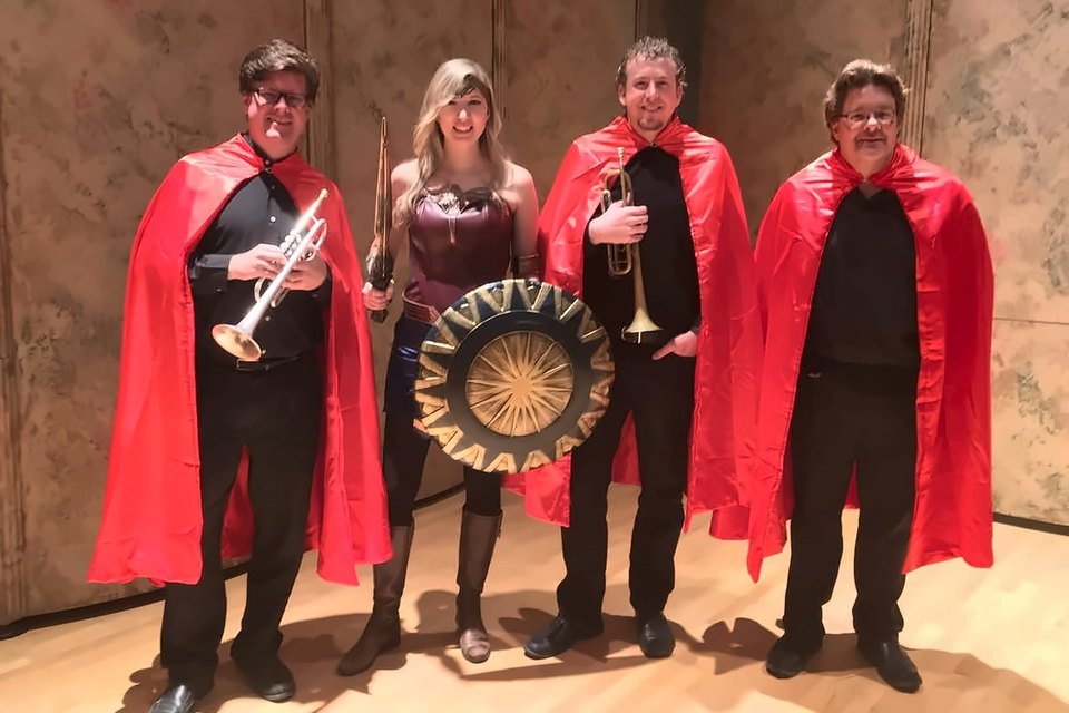 Luis Engelke and three colleagues in red capes, one dressed as Wonder Woman