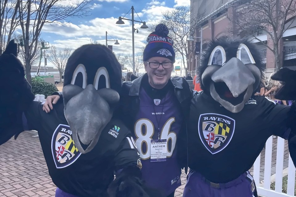 Luis Engelke in a Ravens jersey between two Ravens mascots